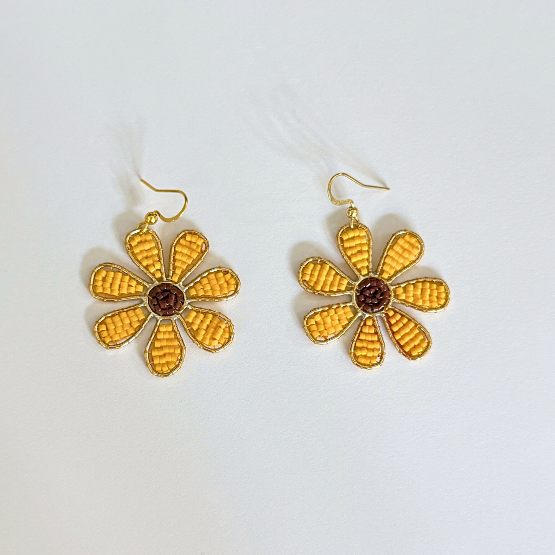 Gold flower-shaped earrings on a white background