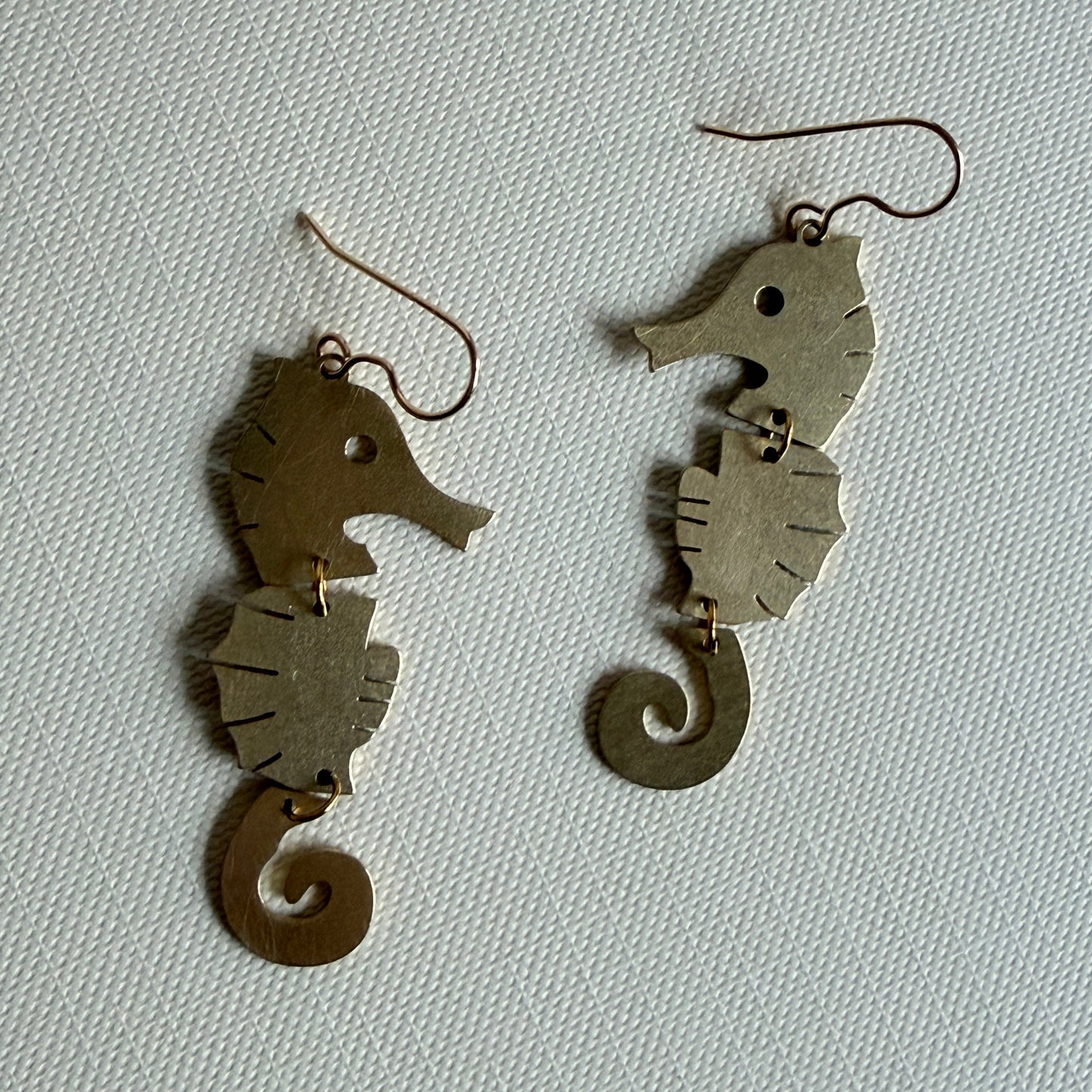 Pair of fish-shaped earrings on a light gray background