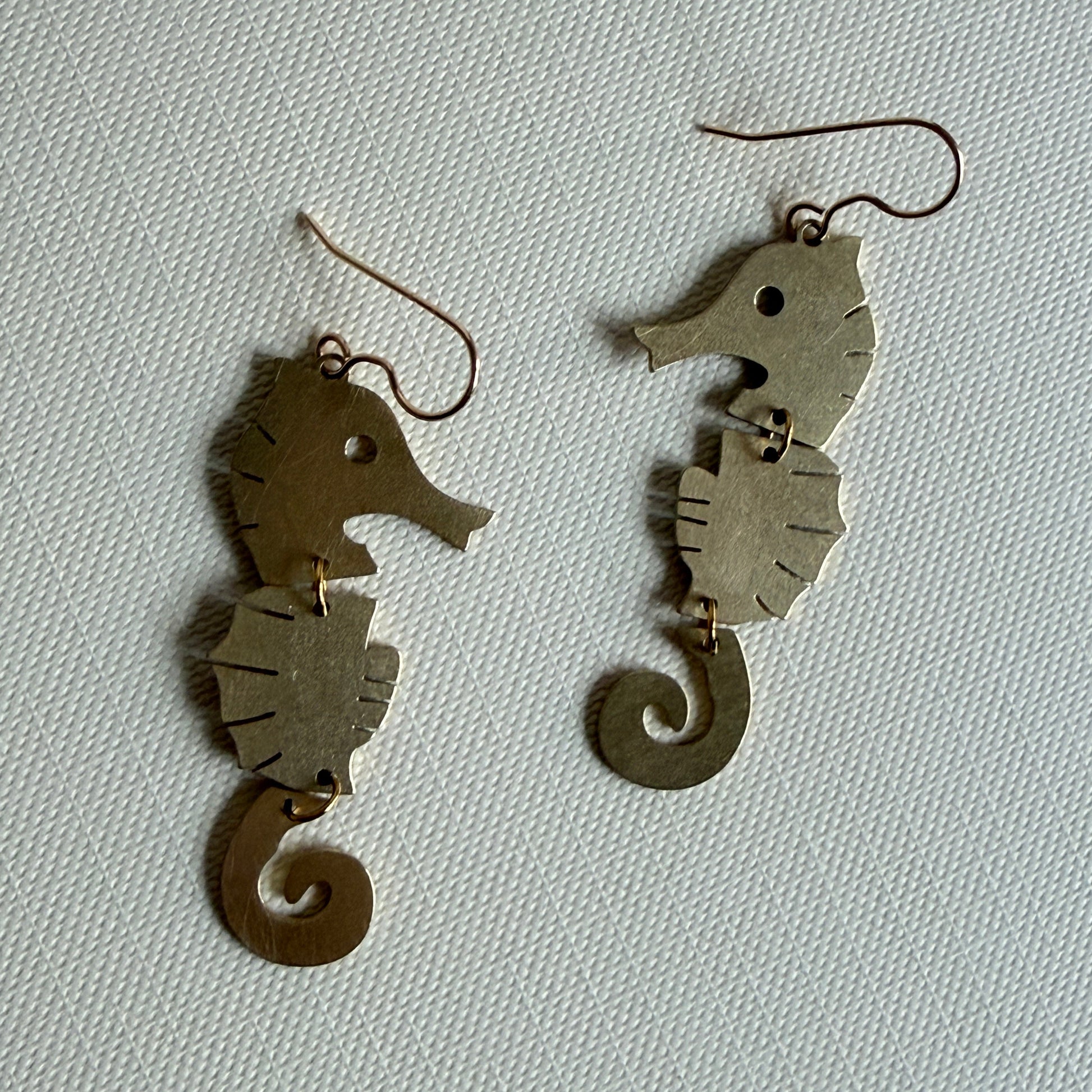 Pair of fish-shaped earrings on a light gray background
