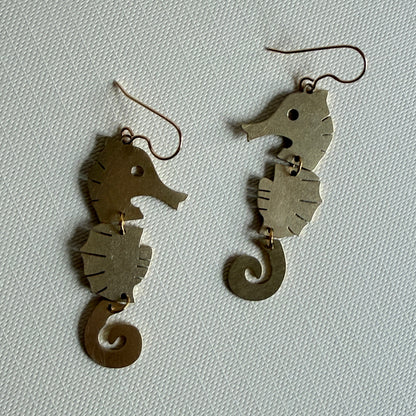 Pair of fish-shaped earrings on a light gray background