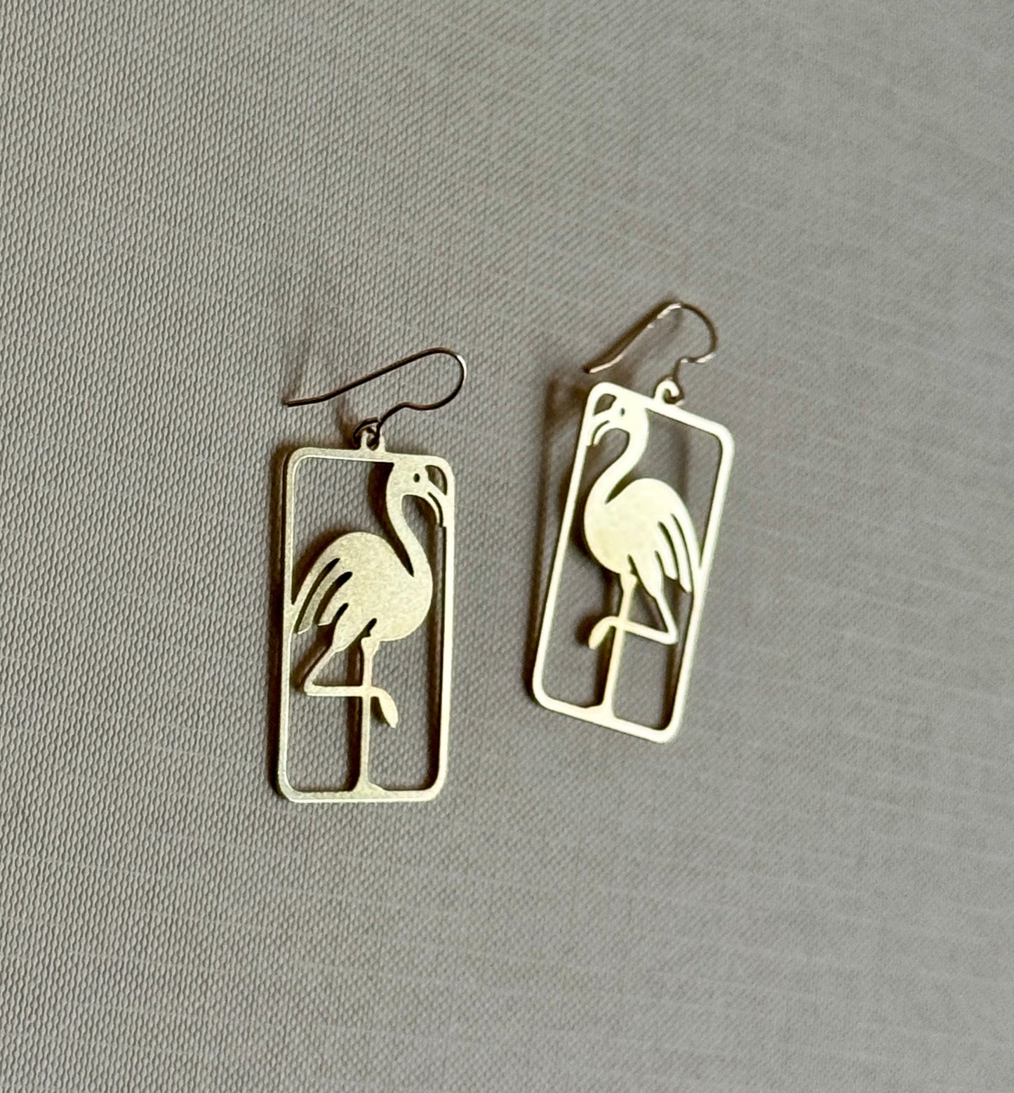 Flamingo-shaped earrings on a gray background