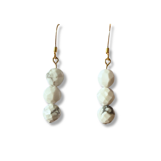 Pair of earrings with three round stones on a white background