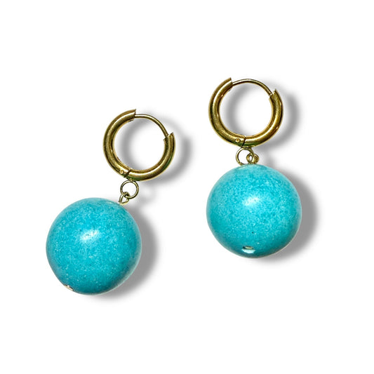 Turquoise bead earrings with gold hoop components on a white background